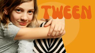 Tween girl with gray t-shirt, white tutu, and black & white striped tights sits with arms wrapped around knees.